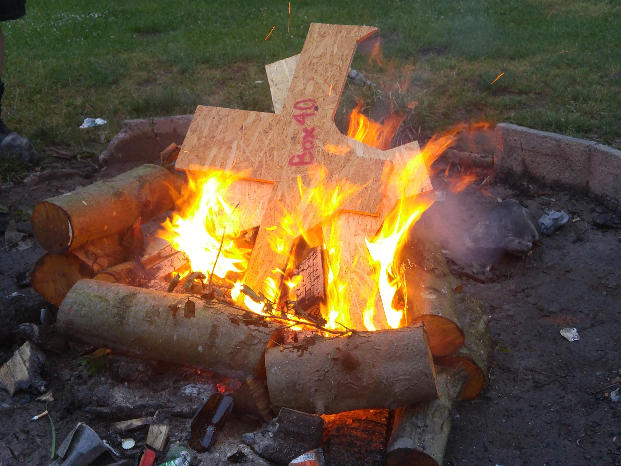 Holzbrett mit "Box 4.0"-Aufschrift verbrennt im Feuer